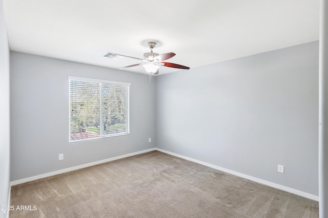 carpeted empty room featuring ceiling fan and baseboards