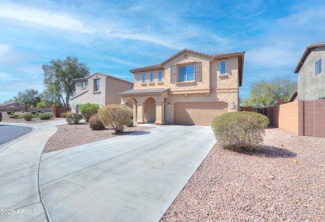 mediterranean / spanish house with fence, a tile roof, stucco siding, a garage, and driveway