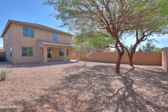 rear view of house with a patio area, central AC unit, a fenced backyard, and stucco siding