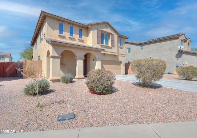 view of front of home with stucco siding, concrete driveway, an attached garage, and fence