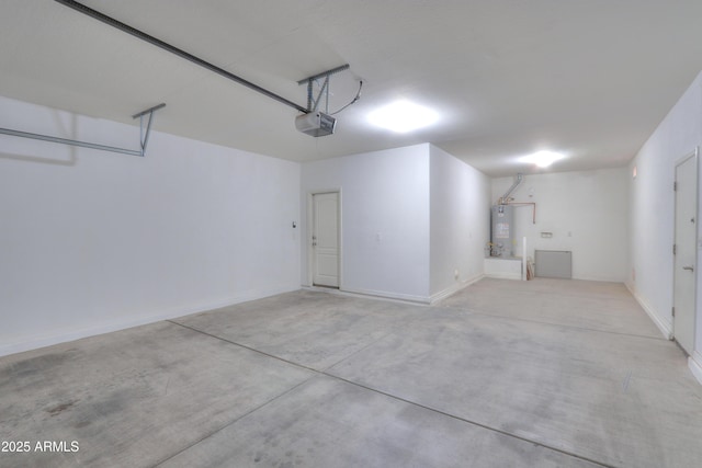 garage featuring water heater, a garage door opener, and baseboards