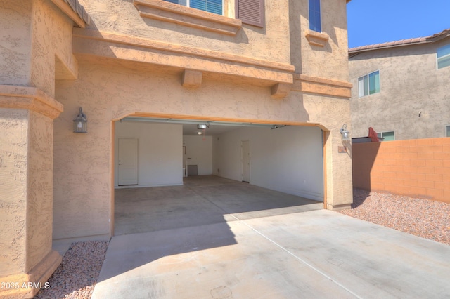 garage featuring driveway and fence