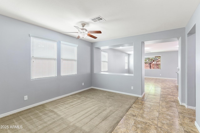 empty room with a ceiling fan, baseboards, and visible vents