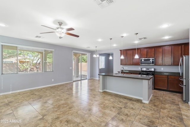 kitchen featuring dark countertops, visible vents, stainless steel appliances, and a sink