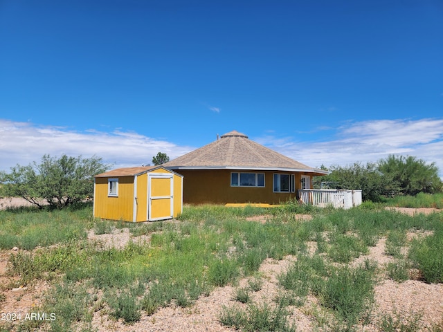 back of property with a storage shed