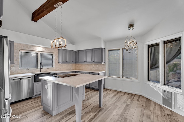 kitchen featuring appliances with stainless steel finishes, a chandelier, gray cabinetry, and light countertops