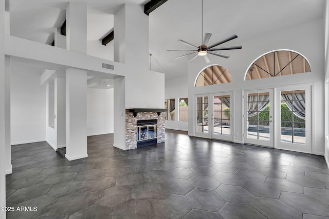 unfurnished living room featuring high vaulted ceiling, a ceiling fan, plenty of natural light, french doors, and beamed ceiling