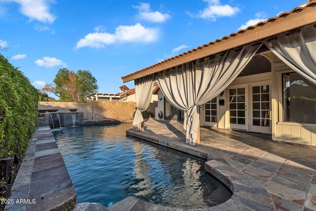 view of pool with a patio, a fenced backyard, and french doors