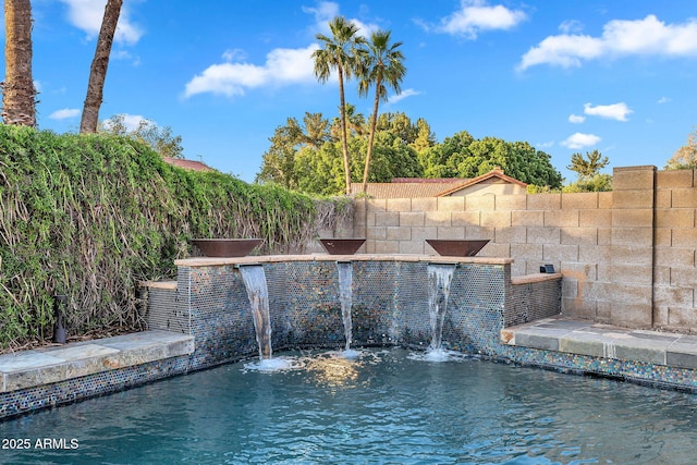 view of swimming pool featuring fence