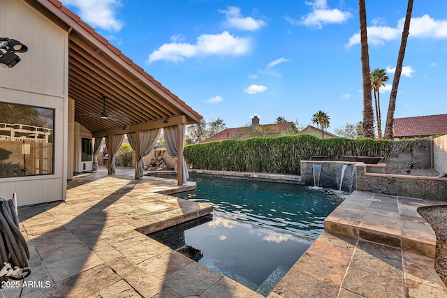 view of pool featuring ceiling fan, a patio, and a fenced backyard