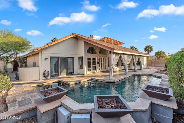 view of swimming pool featuring a fire pit, french doors, and a patio