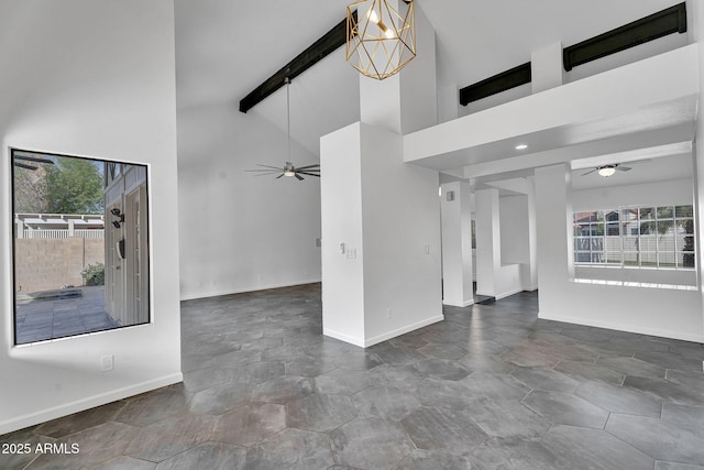 unfurnished living room featuring ceiling fan, high vaulted ceiling, baseboards, and beam ceiling