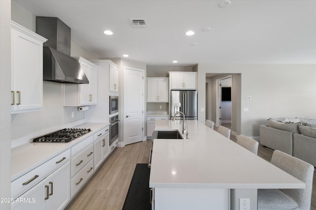 5430 W Notch Hill Rd, Laveen, AZ 85339 - kitchen with stainless steel appliances, a sink, wall chimney exhaust hood, white cabinetry, and light countertops