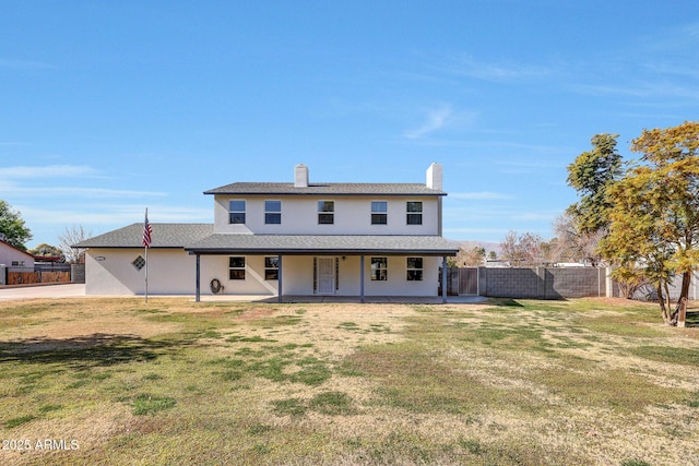 back of property featuring a patio area and a lawn