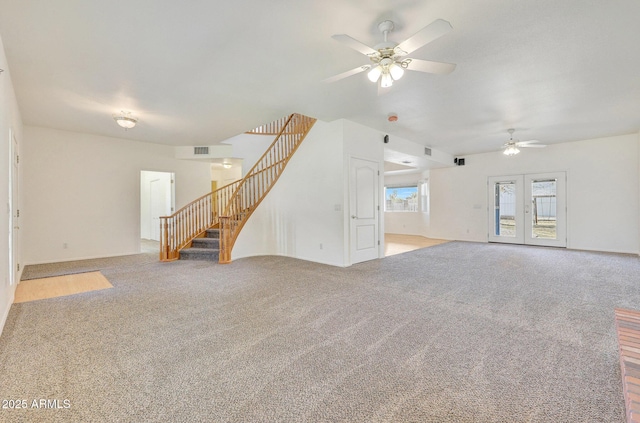 unfurnished living room with french doors, light colored carpet, and ceiling fan