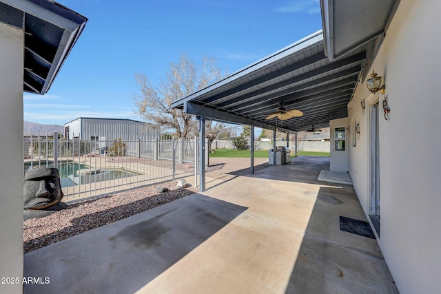 view of patio / terrace with a fenced in pool and ceiling fan