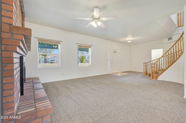 unfurnished living room with a fireplace, ceiling fan, and dark colored carpet