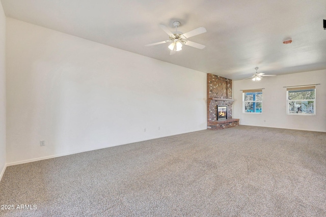 unfurnished living room with ceiling fan, a fireplace, and carpet