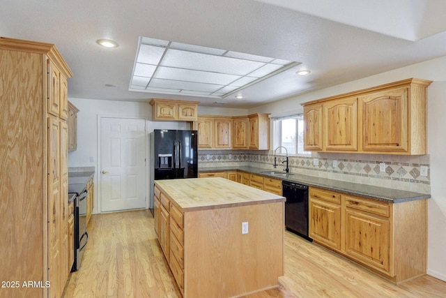 kitchen with wood counters, sink, black appliances, and light hardwood / wood-style floors