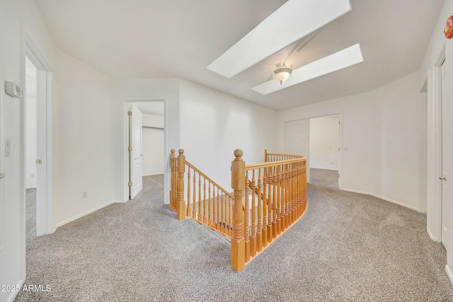 hall featuring a skylight and carpet