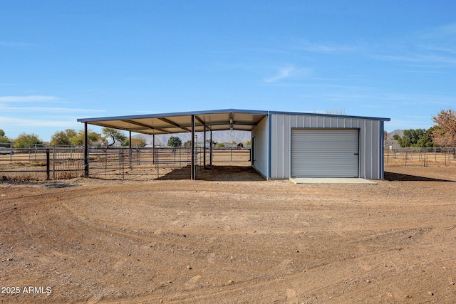 view of outdoor structure featuring a garage and a rural view