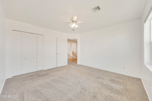 unfurnished bedroom featuring carpet floors, a closet, and ceiling fan