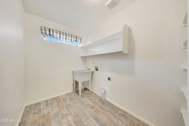 clothes washing area with sink, hookup for an electric dryer, and hookup for a washing machine