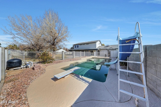 view of pool featuring a patio, a diving board, and a water slide