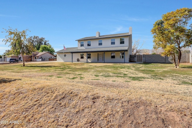 rear view of property featuring a yard