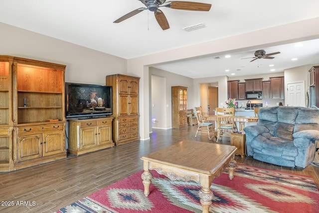 living room with dark hardwood / wood-style floors and ceiling fan