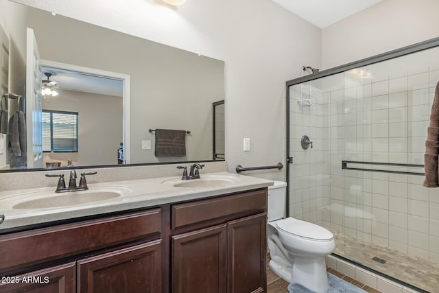 bathroom with vanity, ceiling fan, a shower with door, and toilet