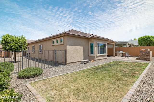 back of house featuring a patio area and a lawn