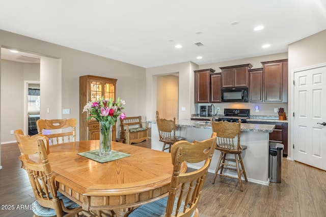 dining room featuring sink and light hardwood / wood-style flooring