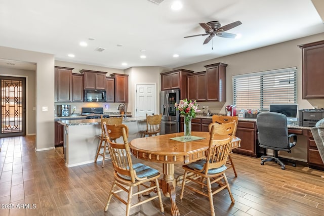 dining space featuring sink, light hardwood / wood-style flooring, and ceiling fan