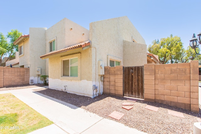 222 W Brown Rd Unit 72, Mesa, AZ 85201 - view of side of property featuring a gate, stucco siding, and a tile roof