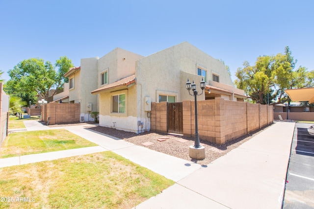 222 W Brown Rd Unit 72, Mesa, AZ 85201 - view of home's exterior featuring stucco siding, a tile roof, and a gate
