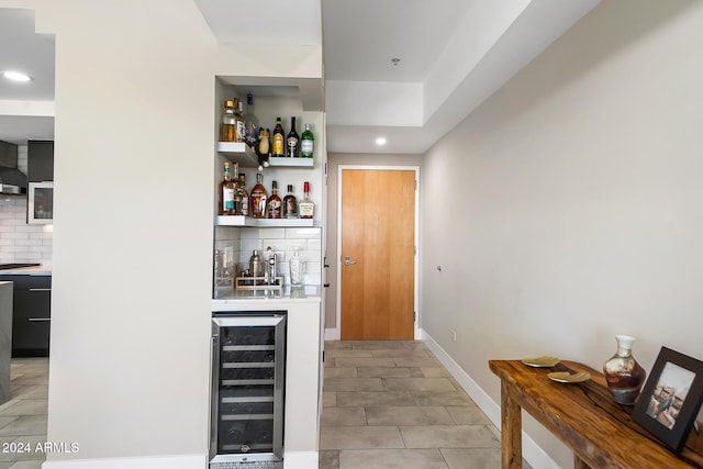 bar with wine cooler, tasteful backsplash, and light tile patterned flooring