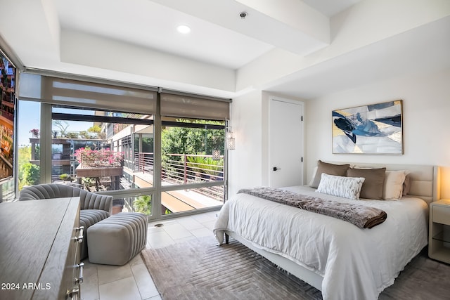 bedroom featuring light tile patterned floors, access to outside, multiple windows, and a wall of windows