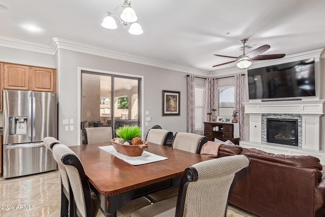 dining area featuring crown molding and ceiling fan with notable chandelier