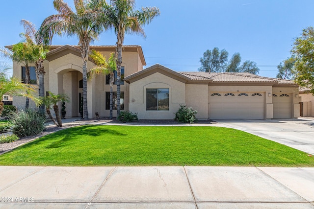 mediterranean / spanish house featuring a garage and a front yard