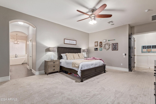 bedroom with ensuite bath, ceiling fan, and carpet