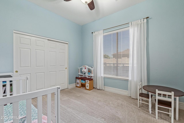 bedroom with ceiling fan, light colored carpet, and a closet