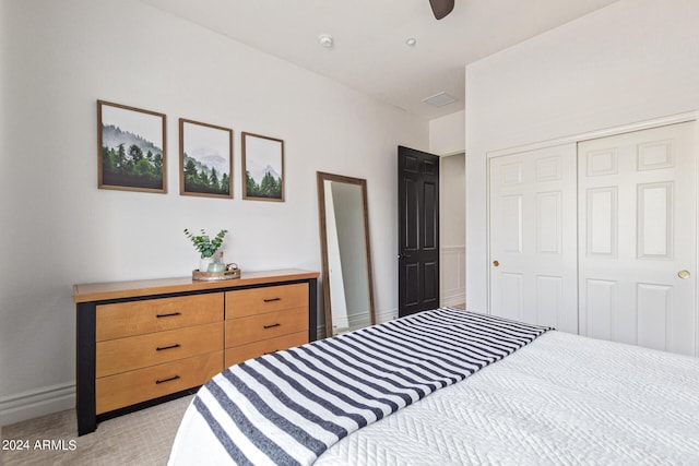 carpeted bedroom featuring ceiling fan and a closet