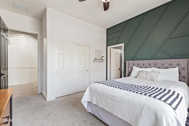 bedroom with light carpet, a closet, and ceiling fan