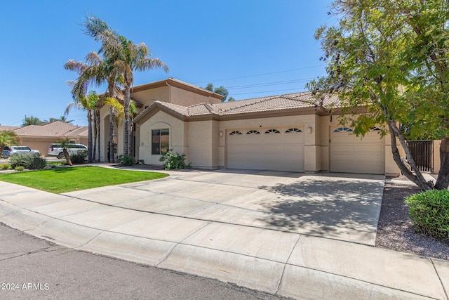 mediterranean / spanish-style house with a garage and a front lawn