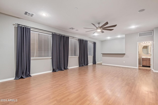 unfurnished living room featuring ceiling fan and light wood-type flooring