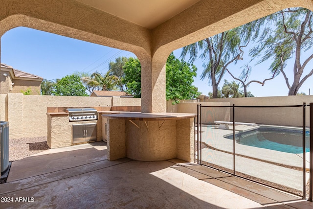 view of patio with a fenced in pool, area for grilling, and grilling area