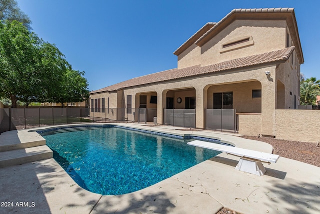 view of swimming pool featuring a diving board and a patio area