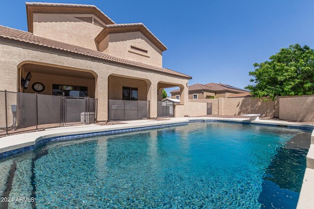 view of swimming pool with a diving board