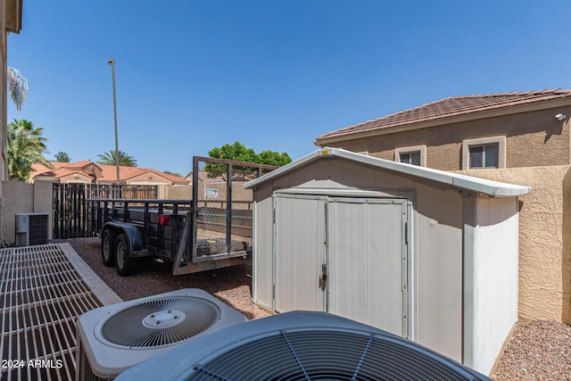 exterior space featuring central AC unit and a shed